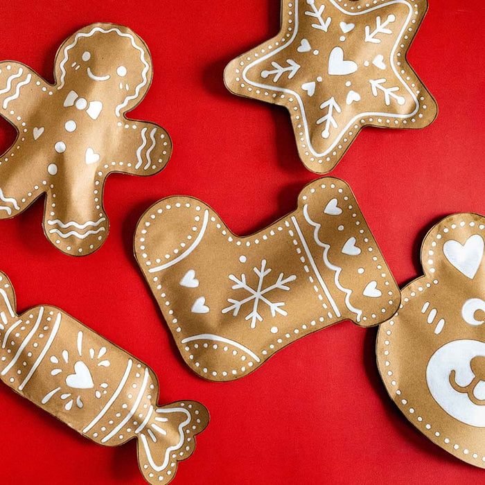 Kreative Weihnachtsgeschenke selber verpacken – handgemachte Lebkuchen-Geschenktüten aus Kraftpapier mit liebevollen weissen Verzierungen auf festlich rotem Hintergrund.