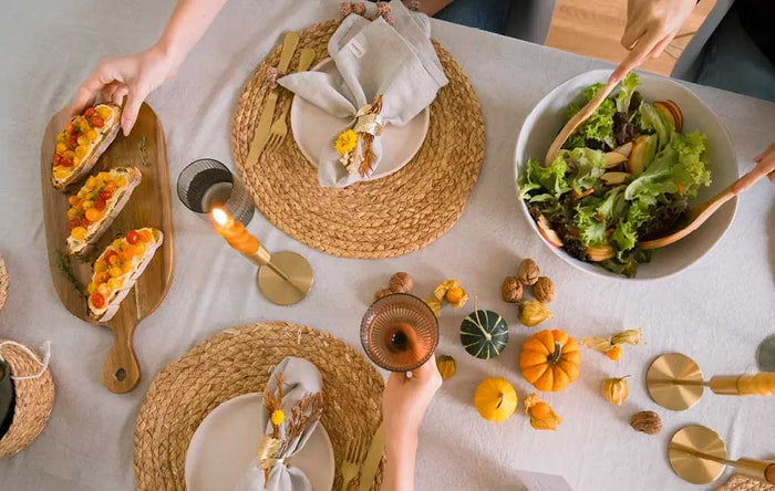 Herbstlich gedeckter Esstisch mit Salat, Bruschetta, Mini-Kürbissen, Walnüssen und natürlicher Dekoration lädt zu einem gemütlichen Dinner mit Familie und Freunden ein.